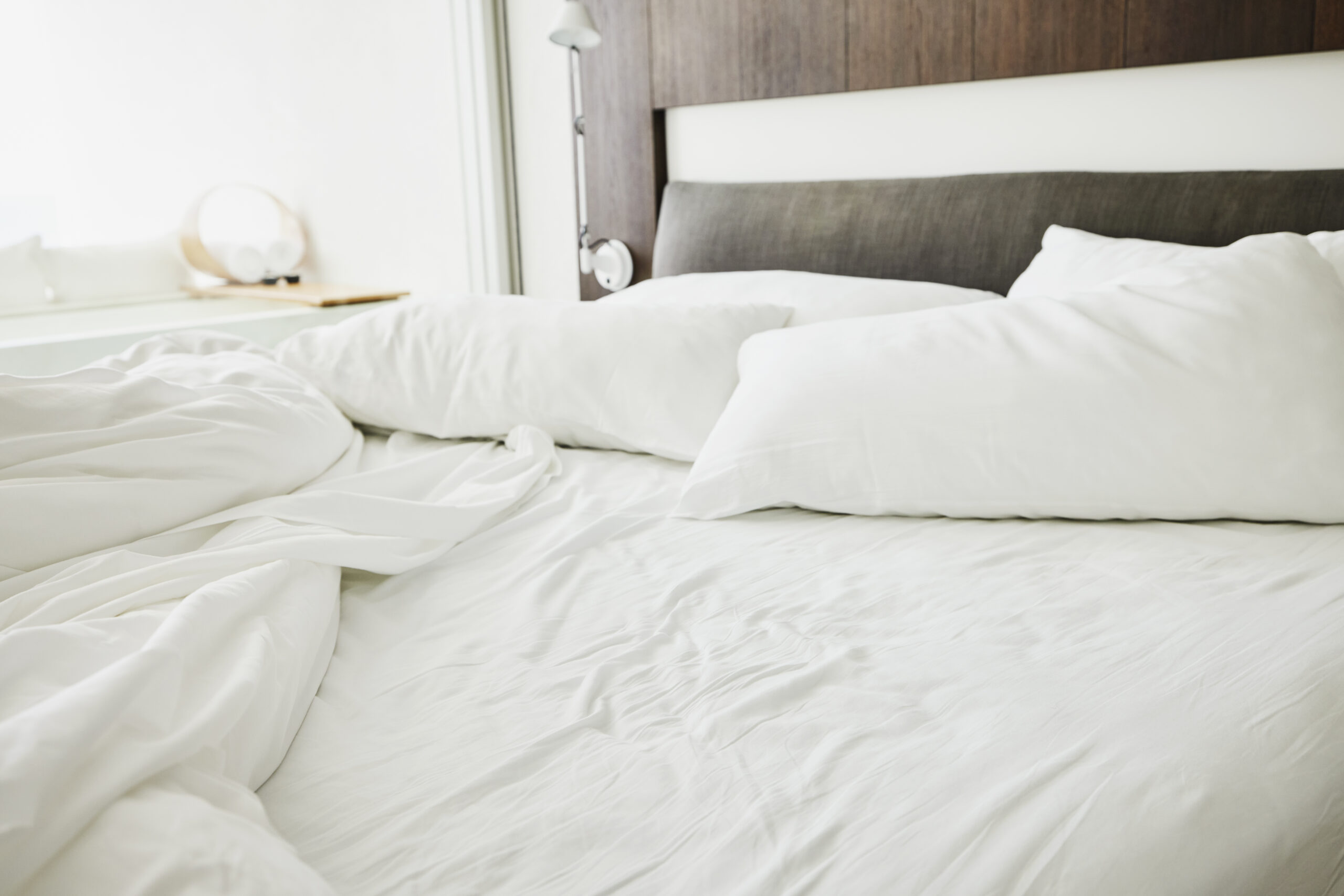 Medium shot of unmade bed in luxury hotel room